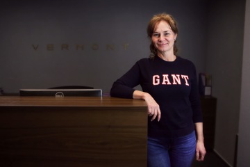 Imageová fotka muže v bílé košili hledícího do dálky sedícího ve člunu na moři s horizontem v pozadí