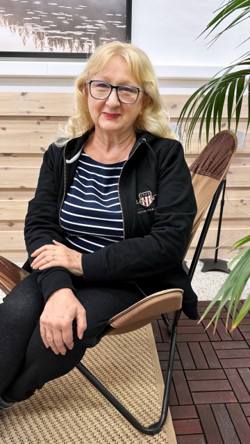 Imageová fotka muže v bílé košili hledícího do dálky sedícího ve člunu na moři s horizontem v pozadí