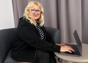 Imageová fotka muže v bílé košili hledícího do dálky sedícího ve člunu na moři s horizontem v pozadí